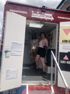 Jules Losee and their partner inside the Humanities Truck, giving a thumbs up